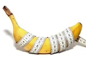 Banana with a measuring tape around it.